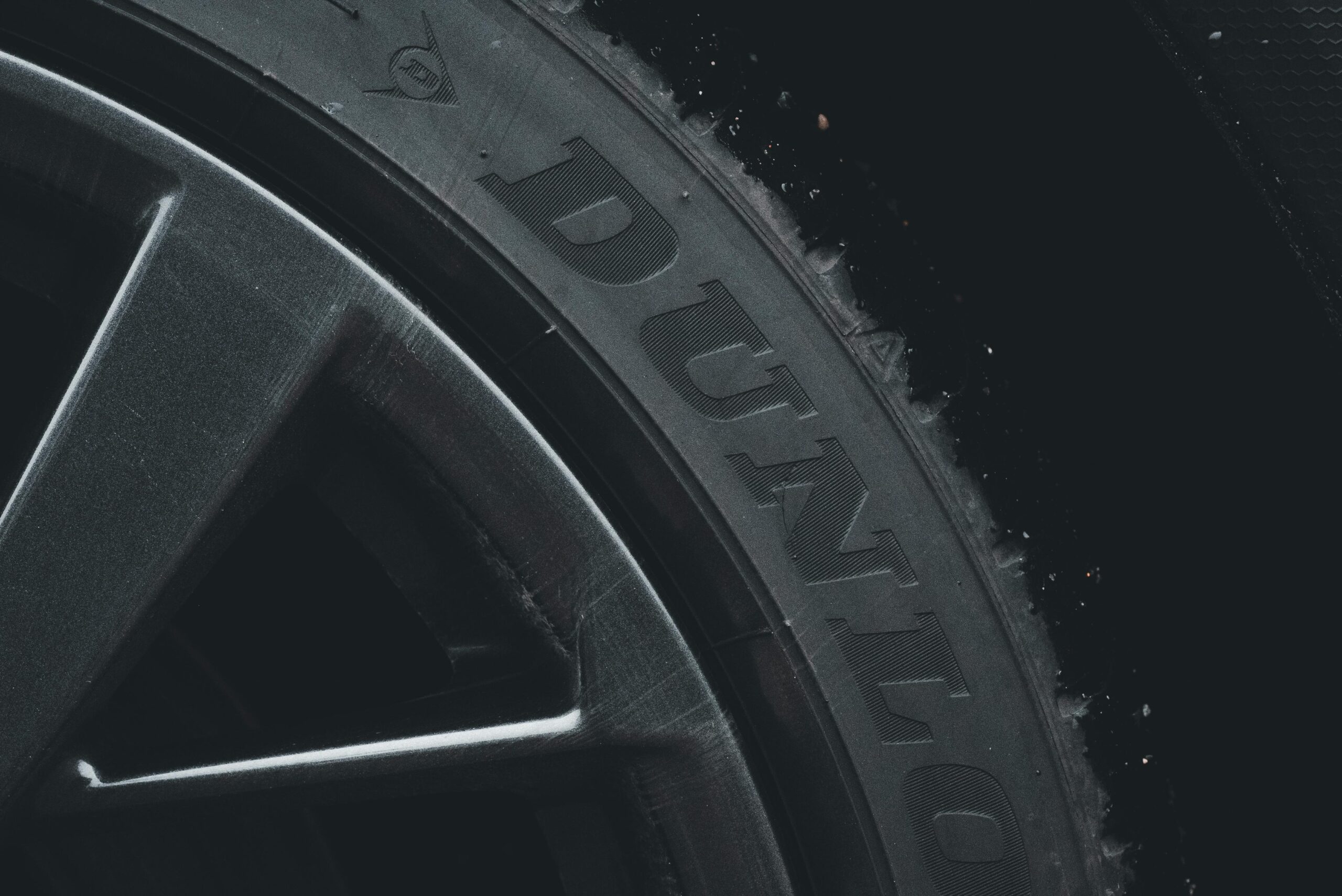 Close-up of a Dunlop car tire on a black alloy wheel